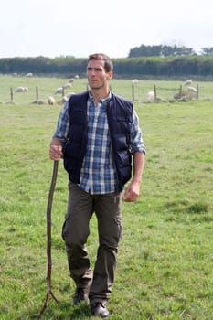 Shepherd standing in pasture land