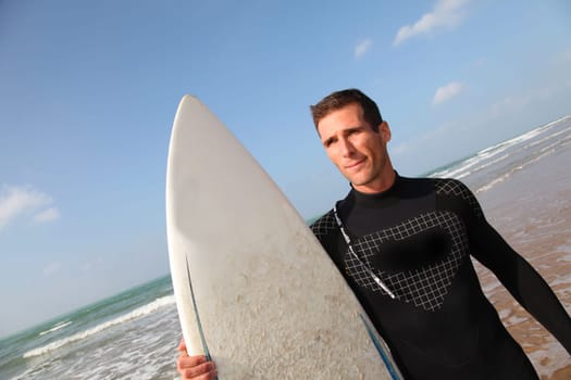 Man holding surfboard at the beach