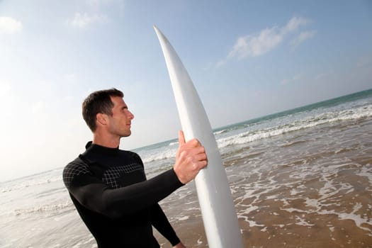 Man holding surfboard at the beach