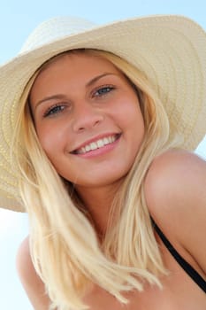 Closeup of beautiful blond woman wearing hat at the beach