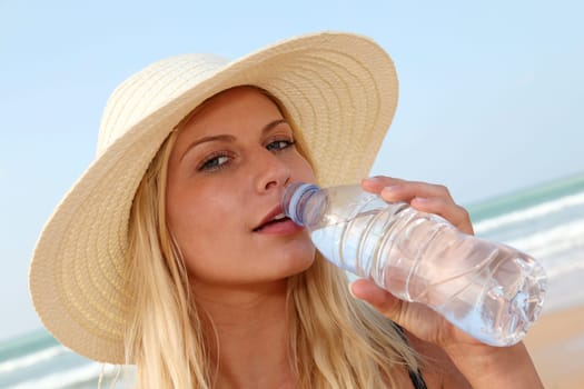 Closeup of woman drinking water at the beach