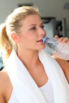 Woman drinking water after exercising