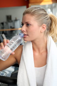 Woman drinking water after exercising