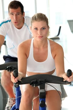 Man and woman doing indoor biking