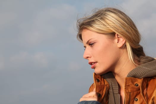 Closeup of woman sitting by the beach in autumn