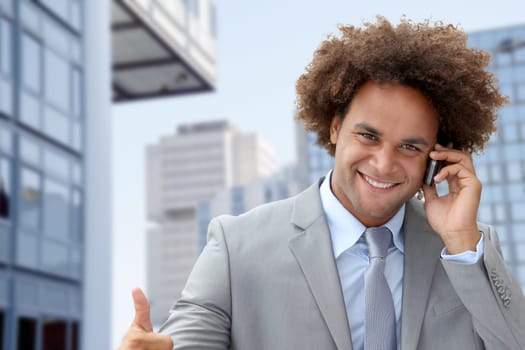 Businessman on the phone in front of modern building