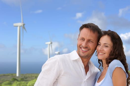 Couple standing in front of wine turbines