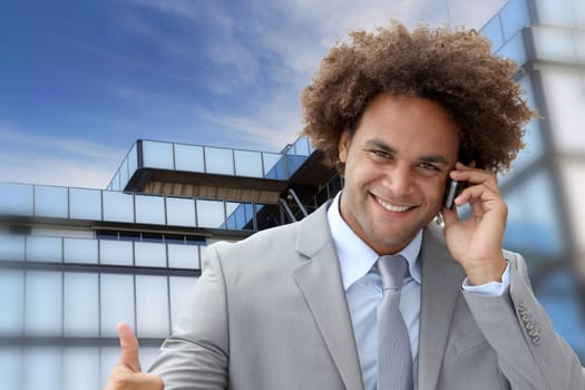 Businessman on the phone in front of modern building