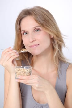 Closeup of beautiful blond woman eating cereals