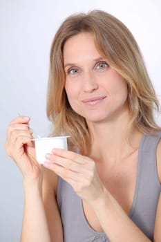 Closeup of beautiful woman eating yogurt