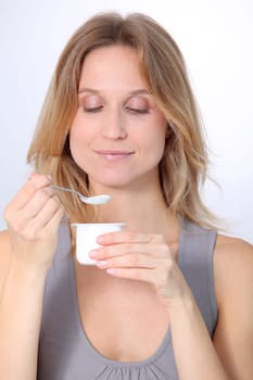 Closeup of beautiful woman eating yogurt