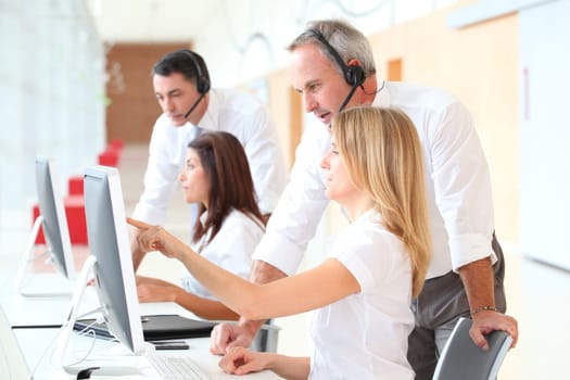 Business people working in front of computer with headphones