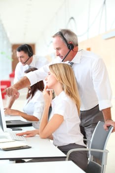 Business people working in front of computer with headphones