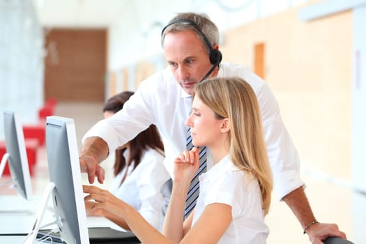 Business people working in front of computer with headphones