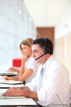Business people working in front of computer with headphones