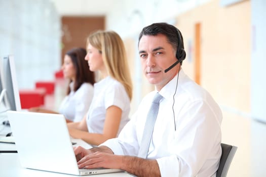 Business people working in front of computer with headphones