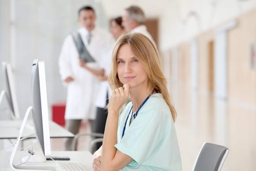 Portrait of beautiful nurse in front of medical people