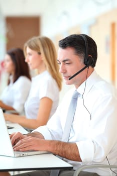 Business people working in front of computer with headphones