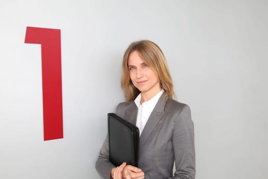 Businesswoman standing in hall against wall