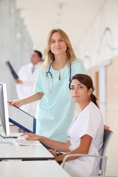 Nurse with intern working in front of computer