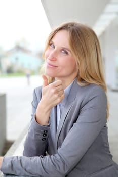 Closeup of blond businesswoman standing outside