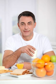 Smiling adult man having breakfast
