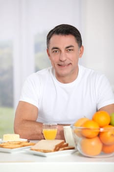 Smiling adult man having breakfast