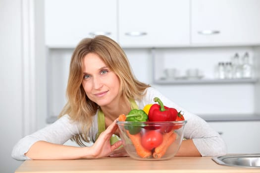 Woman in kitchen ready to prepare meal with vegetables