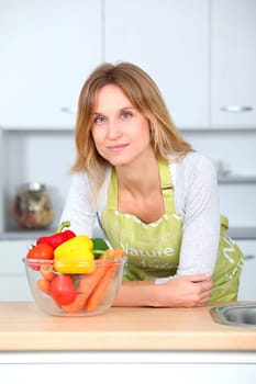 Woman in kitchen ready to prepare meal with vegetables