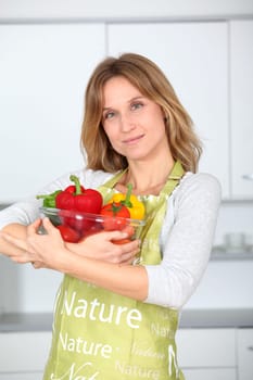 Woman in kitchen ready to prepare meal with vegetables