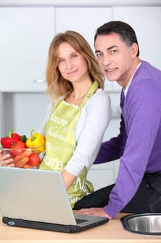 Couple in kitchen looking for cooking receipe