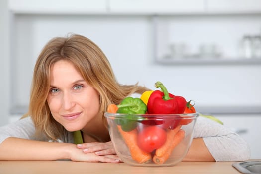 Woman in kitchen ready to prepare meal with vegetables