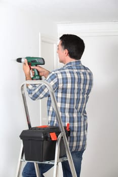 Man using electric drill at home