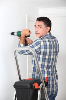 Man using electric drill at home