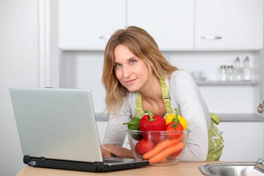 Woman in kitchen looking for cooking receipe