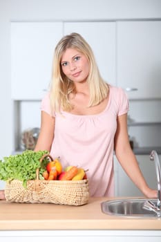 Smiling woman holding basket of organic food