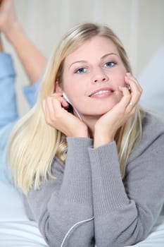 Beautiful blond woman at home with headphones on