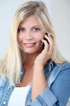 Closeup of beautiful blond woman talking on mobile phone