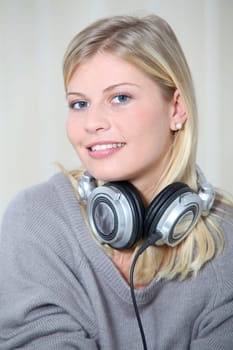 Beautiful blond woman at home with headphones on