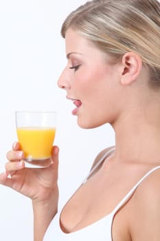 Beautiful blond woman holding glass of orange juice