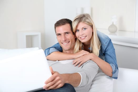 Closeup of couple sitting in sofa surfing on internet