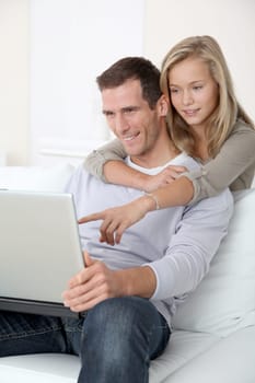 Father and child at home looking at internet
