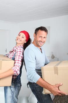Couple holding boxes in their new home