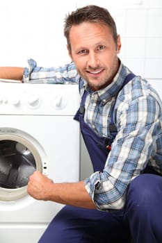 Plumber fixing broken washing machine