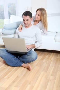 Happy couple surfing on internet at home