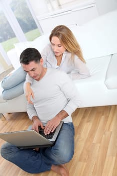 Happy couple surfing on internet at home