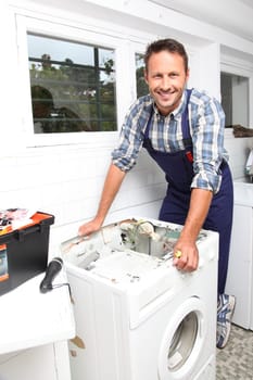 Plumber fixing broken washing machine