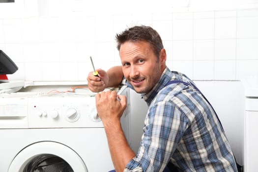 Plumber fixing broken washing machine