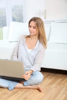 Beautiful blond woman surfing on internet at home