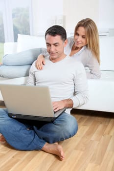 Happy couple surfing on internet at home